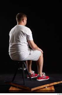 Louis  2 dressed grey shorts red sneakers sitting sports…